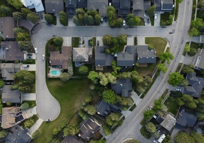 An overhead view of a suburban neighborhood, with a curved cul-de-sac on one side and a wider road running along the other